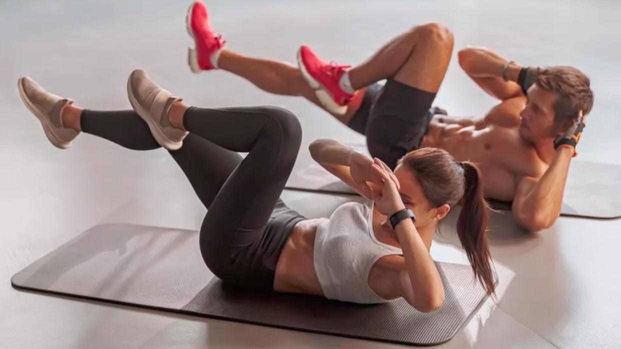  a photo of a man and woman doing bicycle crunches  