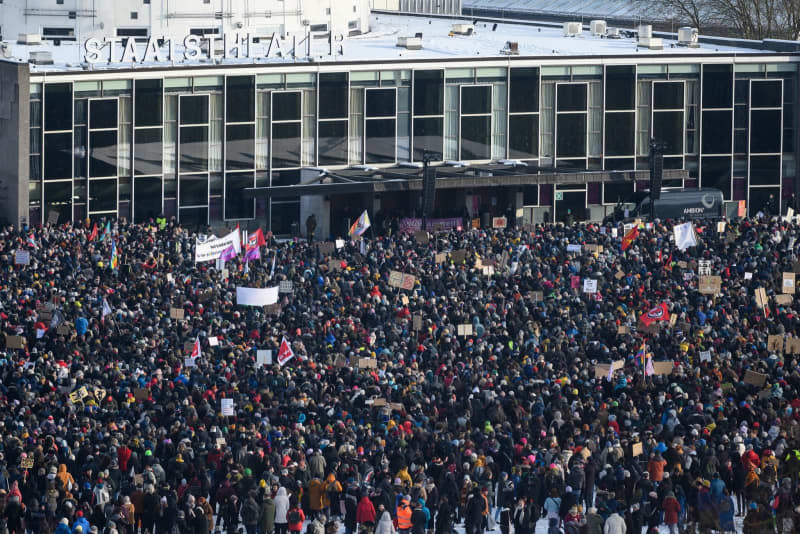 People stand in front of the State Theater during a demonstration against the AfD and right-wing extremism in Hesse. Swen Pförtner/dpa