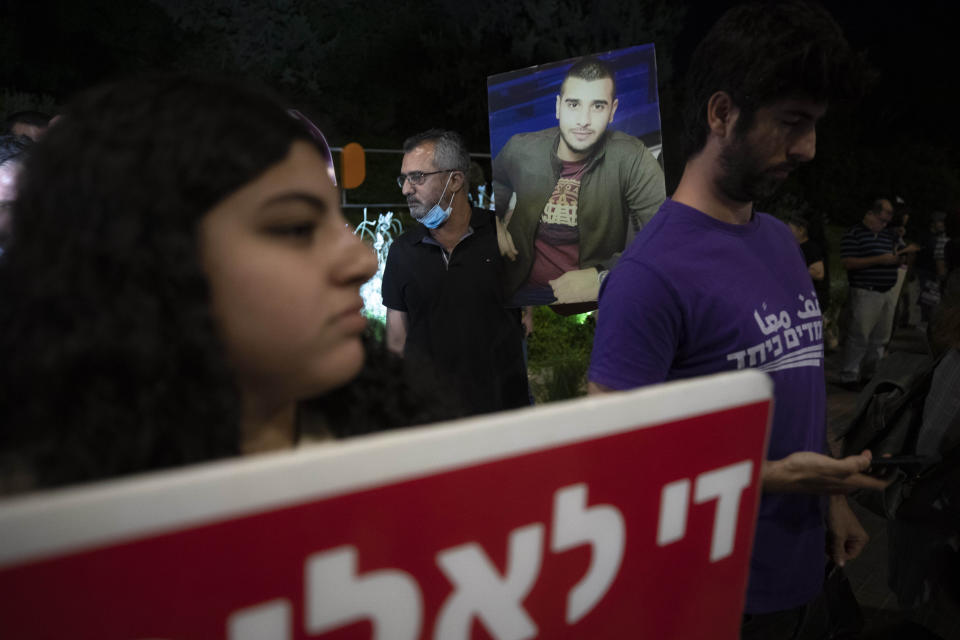 Protesters hold pictures and chant slogans during a demonstration against violence near the house of Public Security Minister Omer Barlev in the central Israeli town of Kokhav Ya'ir, Saturday, Sept. 25, 2021. Arab citizens of Israel are seeking to raise awareness about the spiraling rate of violent crime in their communities under the hashtag "Arab lives matter," but unlike a similar campaign in the United States, they are calling for more policing, not less. (AP Photo/Sebastian Scheiner)