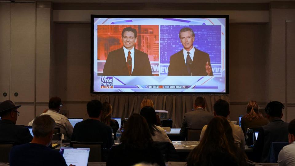 PHOTO: Journalists watch Florida Governor and Republican presidential candidate Ron DeSantis debate California Governor Gavin Newsom on a screen in the media room, in Alpharetta, Georgia, Nov. 30, 2023.  (Elijah Nouvelage/Reuters)