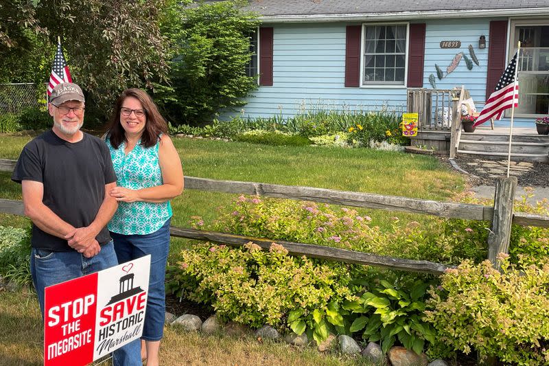 FILE PHOTO: Chapmans pose for a picture in front of their house near a land that will be home to a proposed Ford Motor Co electric vehicle battery plant in Marshall Township