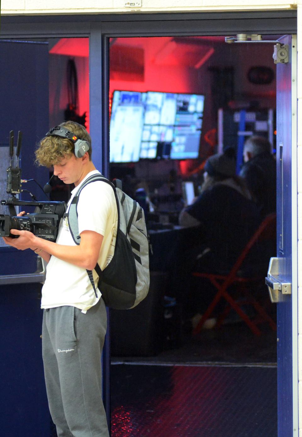 Petoskey student and member of the Rambler Sports Network team, Peyton Harmon, works a camera during a basketball game broadcast recently, as other members of RSN work in the production trailer pulled up to the doors of the Boyne City High School gym.