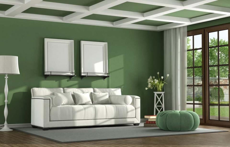 A view of a coffered ceiling in a green living room.