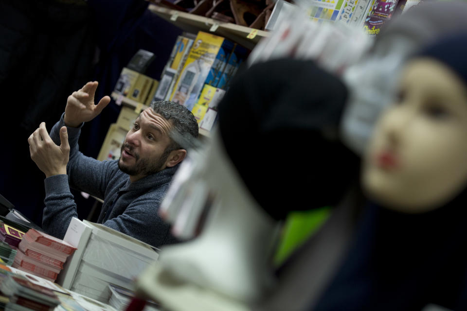 FILE - In this March 19, 2016 file photo, a storekeeper answers questions from a journalist in the Molenbeek neighborhood of Brussels, Belgium. The social fabric is still especially frayed in the rundown Molenbeek municipality in the center of the city, where several of the extremists who were involved in the March 2016 Brussels attacks or the November 2015 Paris attacks had lived or grown up. (AP Photo/Peter Dejong, File)