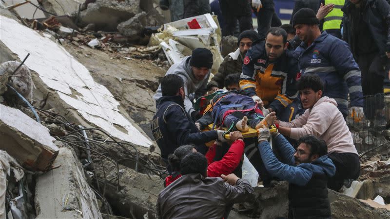 土耳其強震規模7.8，房屋倒塌民眾瓦礫堆中救援受困民眾。(圖／美聯社／達志影像）