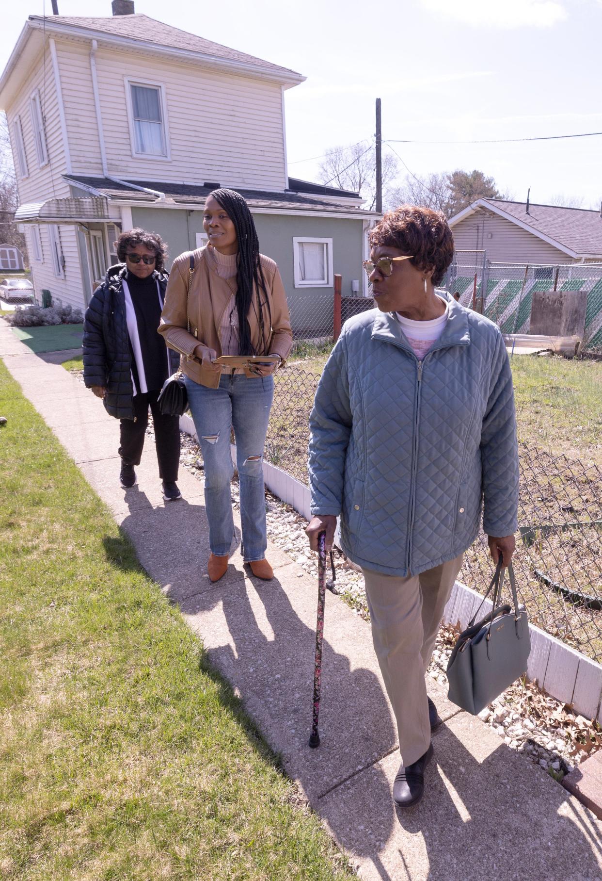 From left, Deborah Johnson-Graham, Kim Manley, and Marie Justice take in the yard and surroundings of their family home in Canton where Habitat for Humanity found the family's hidden heirlooms.
