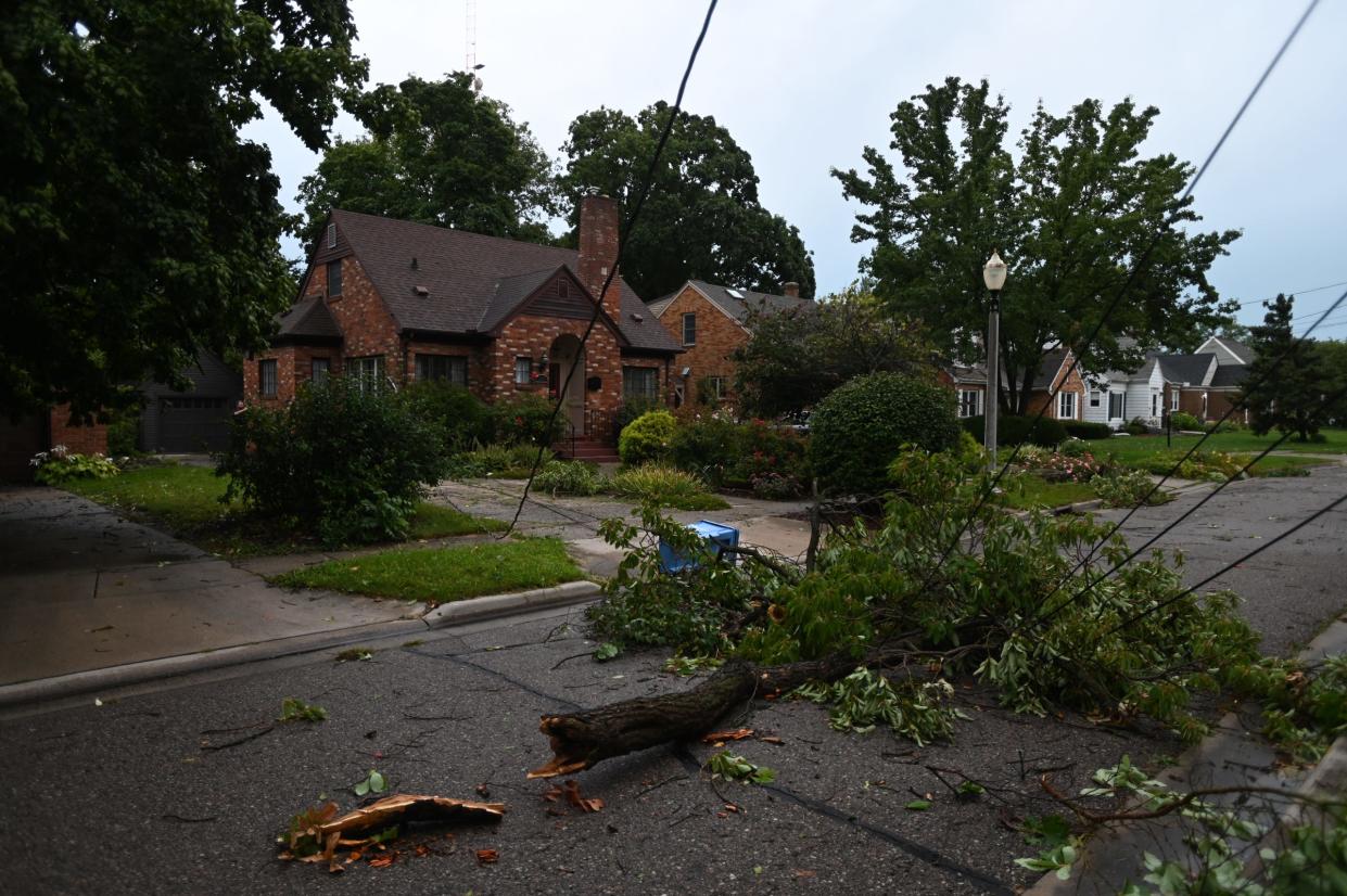 Fallen wires and branches seen at a home near LaSalle Boulevard and East Saginaw Street in Lansing, Tuesday, Aug. 27, 2024.