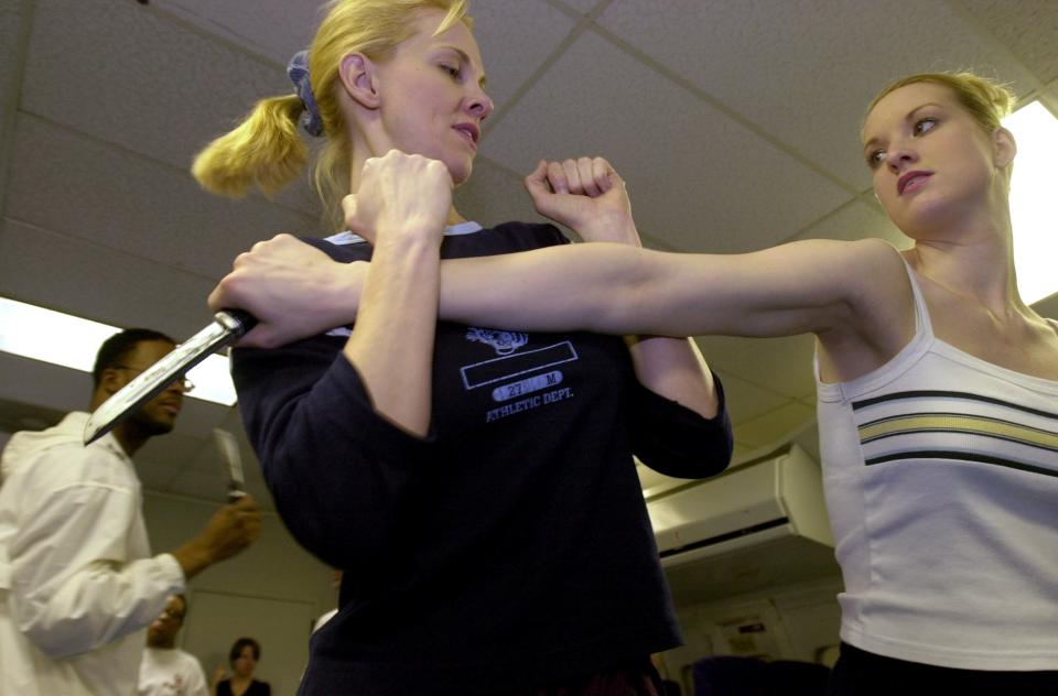 A woman throws a punch at a second woman, who blocks it, during a training.