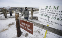 FILE - In this Monday, Jan. 4, 2016, file photo, members of the group occupying the Malheur National Wildlife Refuge headquarters stand guard near Burns, Ore. The divide in Oregon between the state’s liberal, urban population centers and its conservative and economically depressed rural areas makes it fertile ground for the political crisis unfolding over a push by Democrats to enact sweeping climate legislation. Just three years after armed militia members took over the national wildlife refuge in southeastern Oregon, some of the same groups are now seizing on a walkout by Oregon’s GOP senators to broadcast their anti-establishment message. (AP Photo/Rick Bowmer, File)