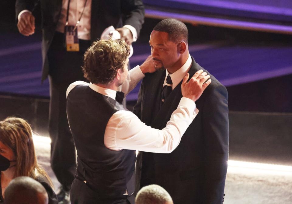 Bradley Cooper comforts Will Smith during the 94th Academy Awards at the Dolby Theatre.