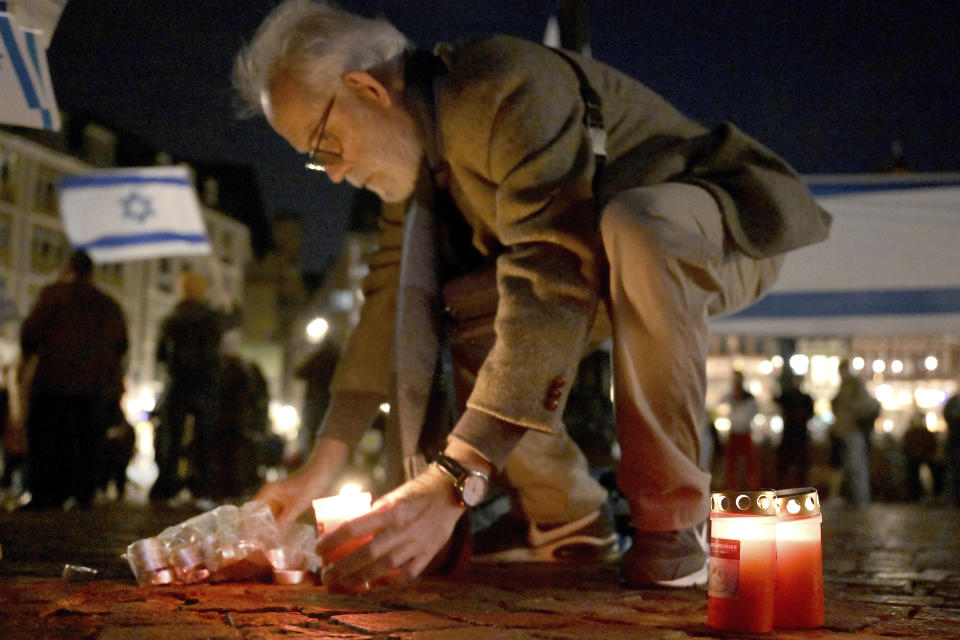 A man lights candles during a pro-Israel solidarity rally in Frankfurt, Germany, Saturday, Oct. 7, 2023. (Hannes P Albert/dpa via AP)
