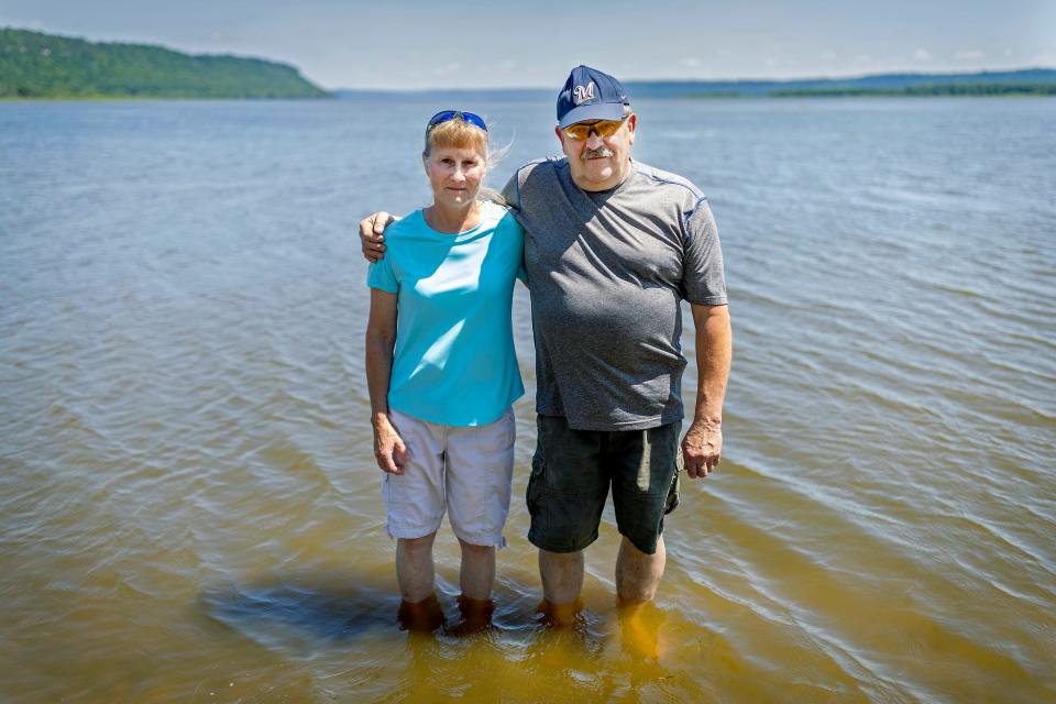 Frank and Cathy Dosdall stand in the water near a beach that should be filled with people in Bay City, a small Wisconsin village about an hour southeast of the Twin Cities. Residents of Bay City have been cut off from accessing Lake Pepin, the largest lake on the Mississippi River, because sediment filling in the lake has made it difficult for boats to pass through and the waters too shallow for swimming.