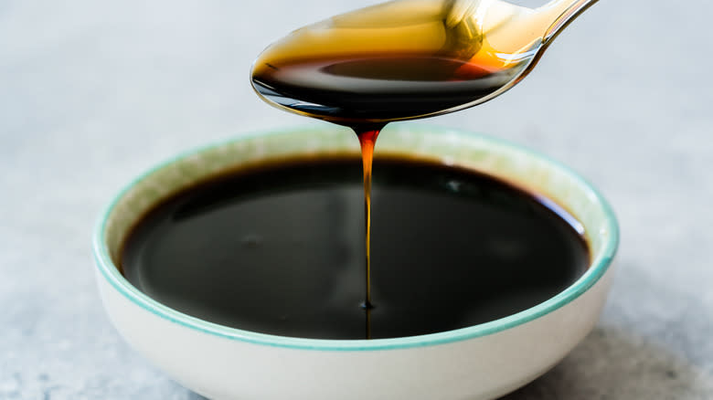 Spoon dripping molasses into bowl