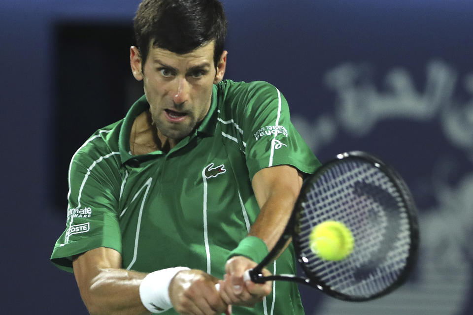 FILE - In this Feb. 29, 2020, file photo, Serbia's Novak Djokovic returns the ball to Stefanos Tsitsipas of Greece during the final match of the Dubai Duty Free Tennis Championship in Dubai, United Arab Emirates. The heads of the ATP and WTA professional tennis tours tell the AP that they are coordinating with each other as they weigh how to reschedule the sport’s calendar for whenever play can resume after the COVID-19 pandemic. (AP Photo/Kamran Jebreili, File)