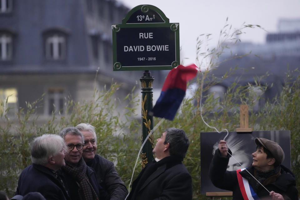 Officials unveil the street sign of singer David Bowie during a ceremony in Paris, Monday, Jan. 8, 2023. The city of Paris is immortalizing late British music icon David Bowie by naming a street after him in the city's southeast on what would have been his 77th birthday on Monday. (AP Photo/Christophe Ena)