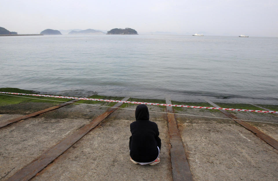 A relative of a passenger aboard the sunken Sewol ferry looks toward the sea as she awaits news on her missing loved one at a port in Jindo, South Korea, Tuesday, April 22, 2014. As divers continue to search the interior of the sunken ferry, the number of confirmed deaths has risen, with about 220 other people still missing. (AP Photo/Ahn Young-joon)
