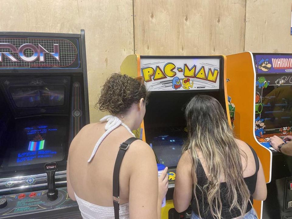 Brie Ceja plays Pac-Man while her friend, Dani Love, watches. Both women competed in the Arcade Game Gauntlet at the California State Fair on Monday. Sonora Slater