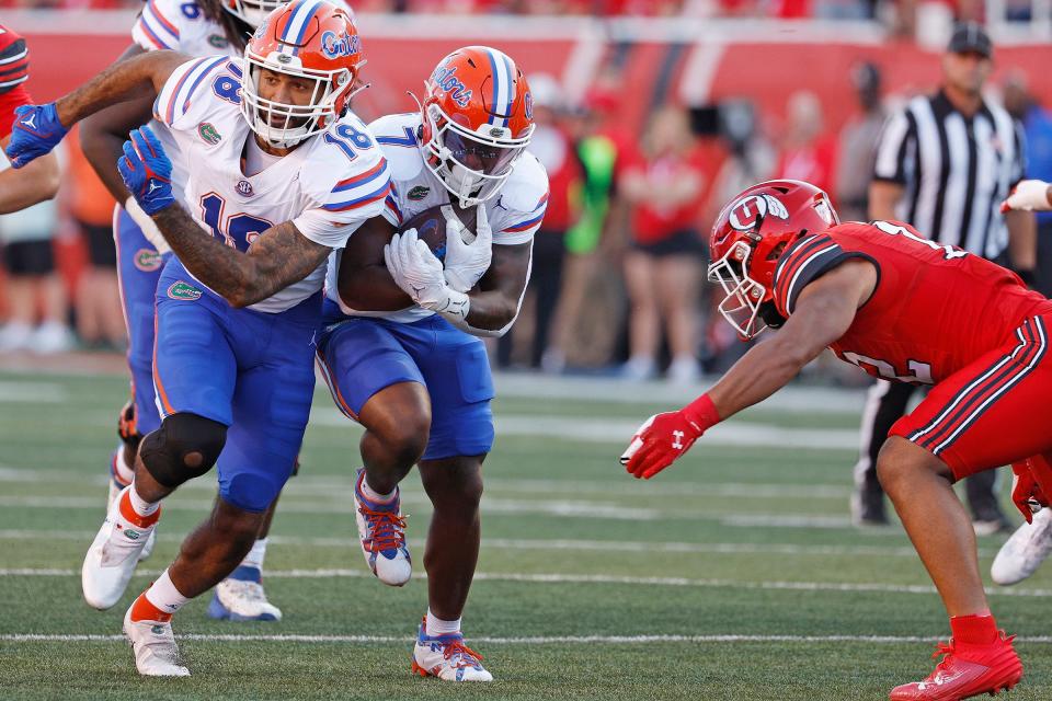 Aug 31, 2023; Salt Lake City, Utah, USA; Florida Gators running back Trevor Etienne (7) runs the ball with help from tight end Dante Zanders (18) in the first half at Rice-Eccles Stadium. Mandatory Credit: Jeff Swinger-USA TODAY Sports