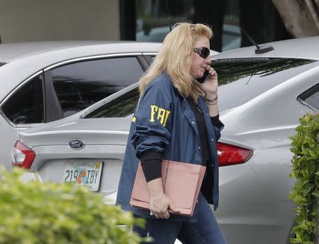 A Federal and state law enforcement official walks outside the office of Med-Care Diabetic and Medical Supplies company during a raid in Boca Raton, Florida, January 14, 2015. REUTERS/Andrew Innerarity