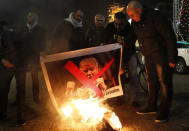 <p>Palestinian protesters burn pictures of President Donald Trump at the manger square in Bethlehem, West Bank on Dec. 5, 2017. (Photo: Musa al-Shaer/AFP/Getty Images) </p>