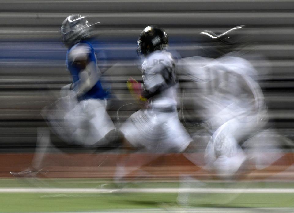 Shown using a slow shutter speed, Estacado's Cedric Ross, far left, runs with the ball against Big Spring,  Thursday, Oct. 27, 2022, at Lowrey Field at PlainsCaptial Park.