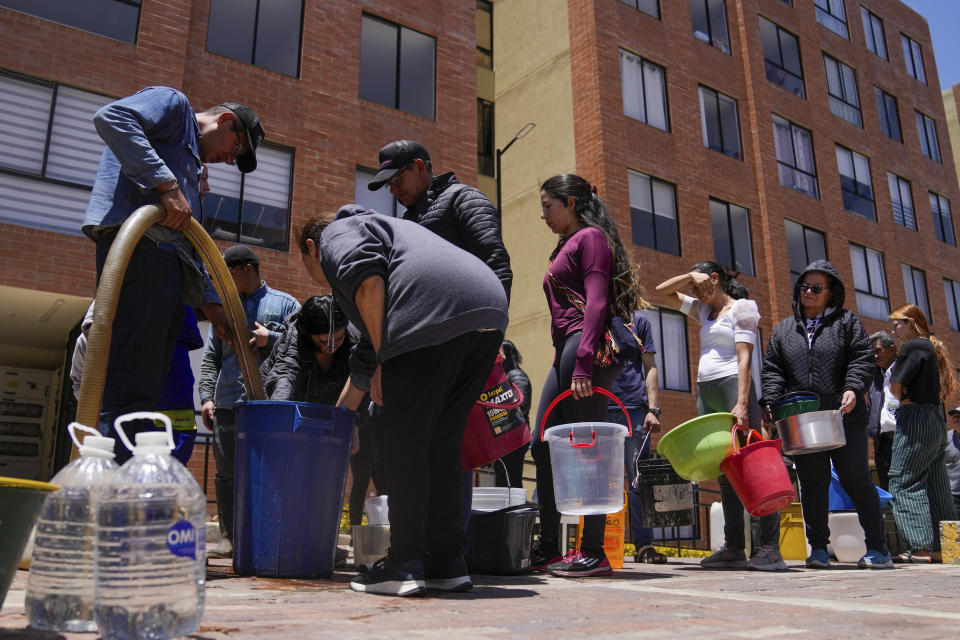 Residents line up to collect water from a truck during water rationing in La Calera, on the outskirts of Bogota, Colombia, Tuesday, April 16, 2024. Amid a drought linked to the El Niño weather pattern, several regions of Colombia have adopted measures to curb water consumption while reservoirs are low. (AP Photo/Fernando Vergara)