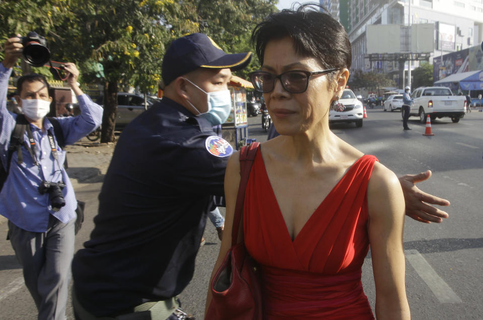 Theary Seng, right, a Cambodian-American lawyer, talks as she walks in front of Phnom Penh Municipal Court in Phnom Penh, Cambodia, Thursday, Jan. 14, 2021. Theary Seng said Thursday she was being persecuted for her political opinion as she and dozens of other government critics charged with treason and other offenses returned to court in a trial criticized by rights advocates. (AP Photo/Heng Sinith)