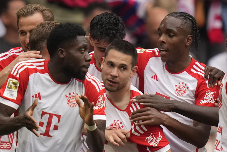 Bayern's Raphael Guerreiro, centre, celebrates after scoring his side's opening goal during the German Bundesliga soccer match between Bayern Munich and Cologne at the Allianz Arena in Munich, Germany, Saturday, April 13, 2024. (AP Photo/Matthias Schrader)