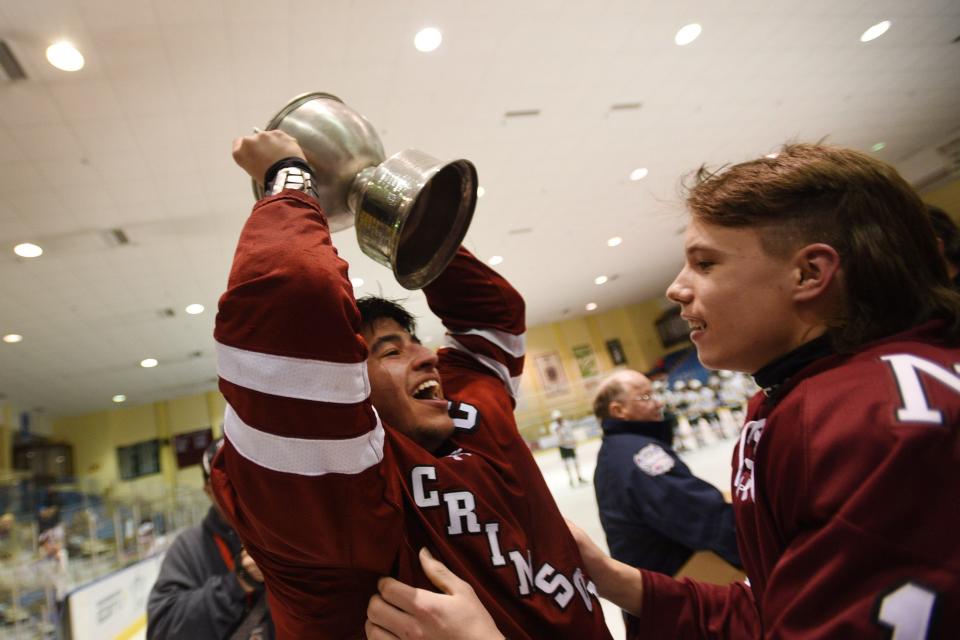 Andrew Low, #17, of Morristown Beard, holds up the championship trophy following their victory 4 -3 against Morris Knolls/Hills in the Mennen Cup Final at Mennen Arena in Morristown on Monday, February 14,2022.