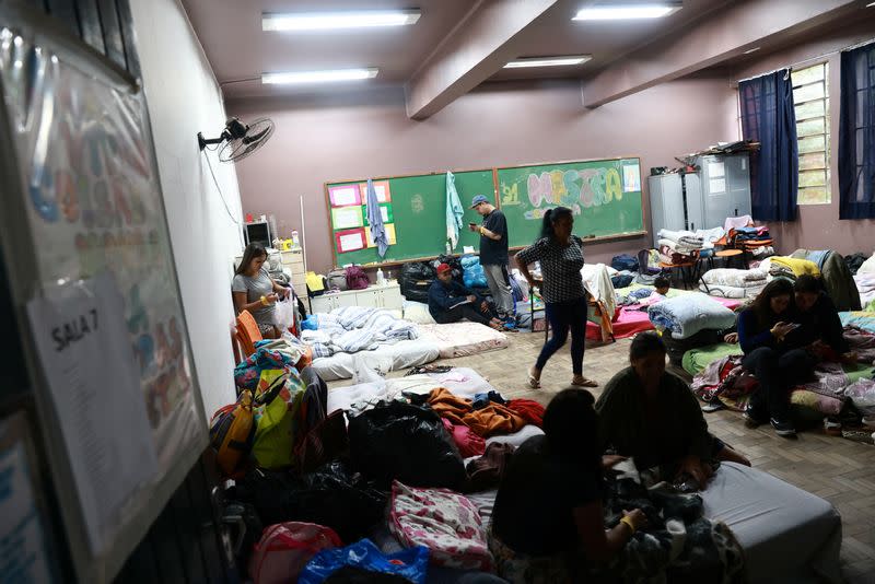 People evacuated from flooded areas, rest inside a classroom in a shelter at a school in Porto Alegre