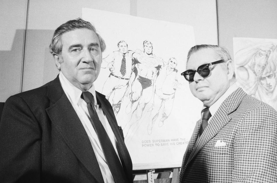 Superman creators Jerry Siegel and Joe Shuster pose in front of sketches of their creation. The pair signed away their rights to royalties for $65 apiece in 1938.