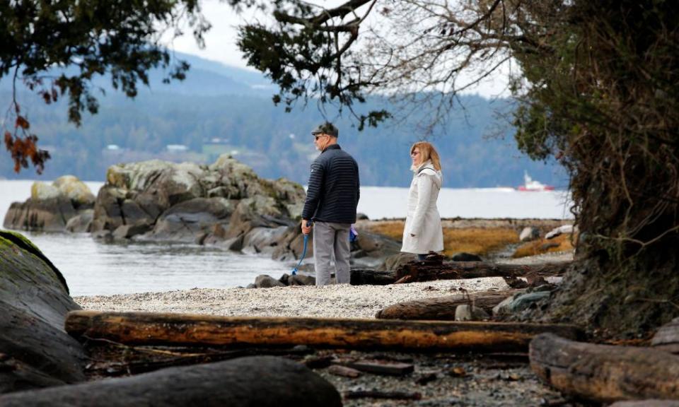 A couple walks on the beach outside the property in North Saanich, British Columbia, where according to news reports Prince Harry and Meghan spent the holidays at the end of 2019.