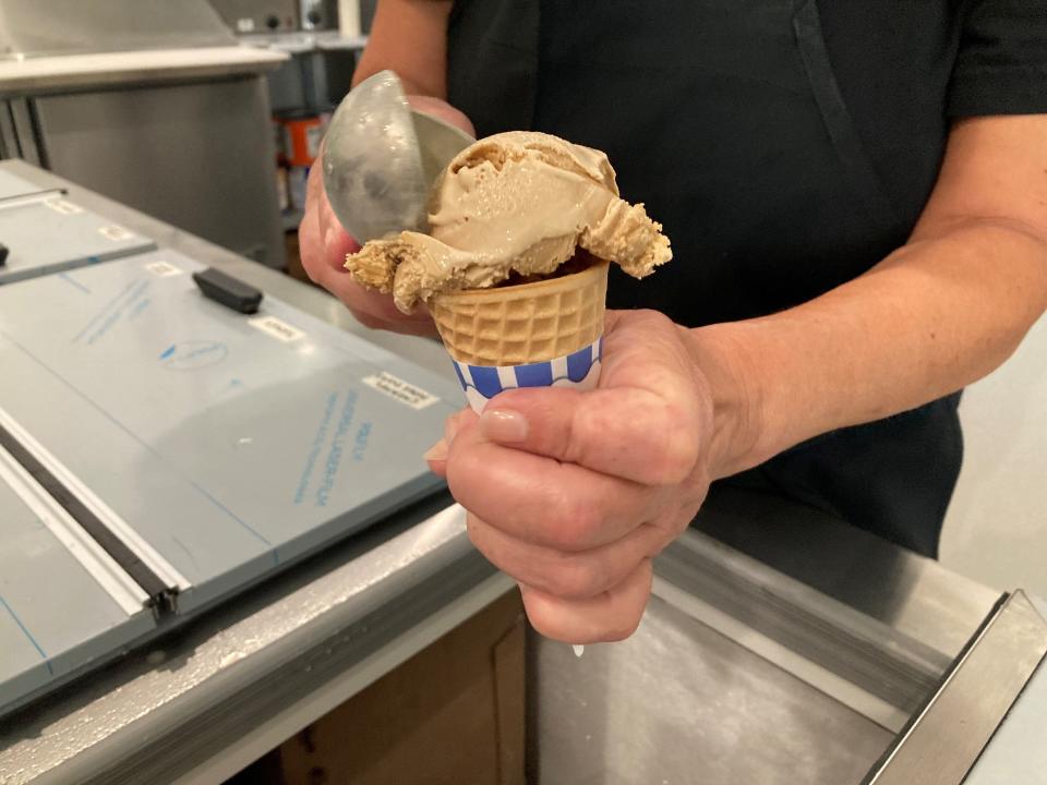 Sidetracks employee Christine Hesson scoops coffee ice cream into a cone.