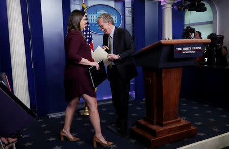 White House Press Secretary Sarah Huckabee Sanders trades places at the podium with U.S. National Security Advisor John Bolton after he announced that the U.S. will withdraw from the Vienna protocol and the 1955 "Treaty of Amity" with Iran and answered questions during a news conference in the White House briefing room in Washington, U.S., October 3, 2018. REUTERS/Leah Millis