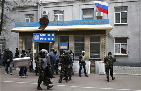 Armed men stand in front of the police headquarters building in Slaviansk, April 12, 2014. REUTERS/Gleb Garanich