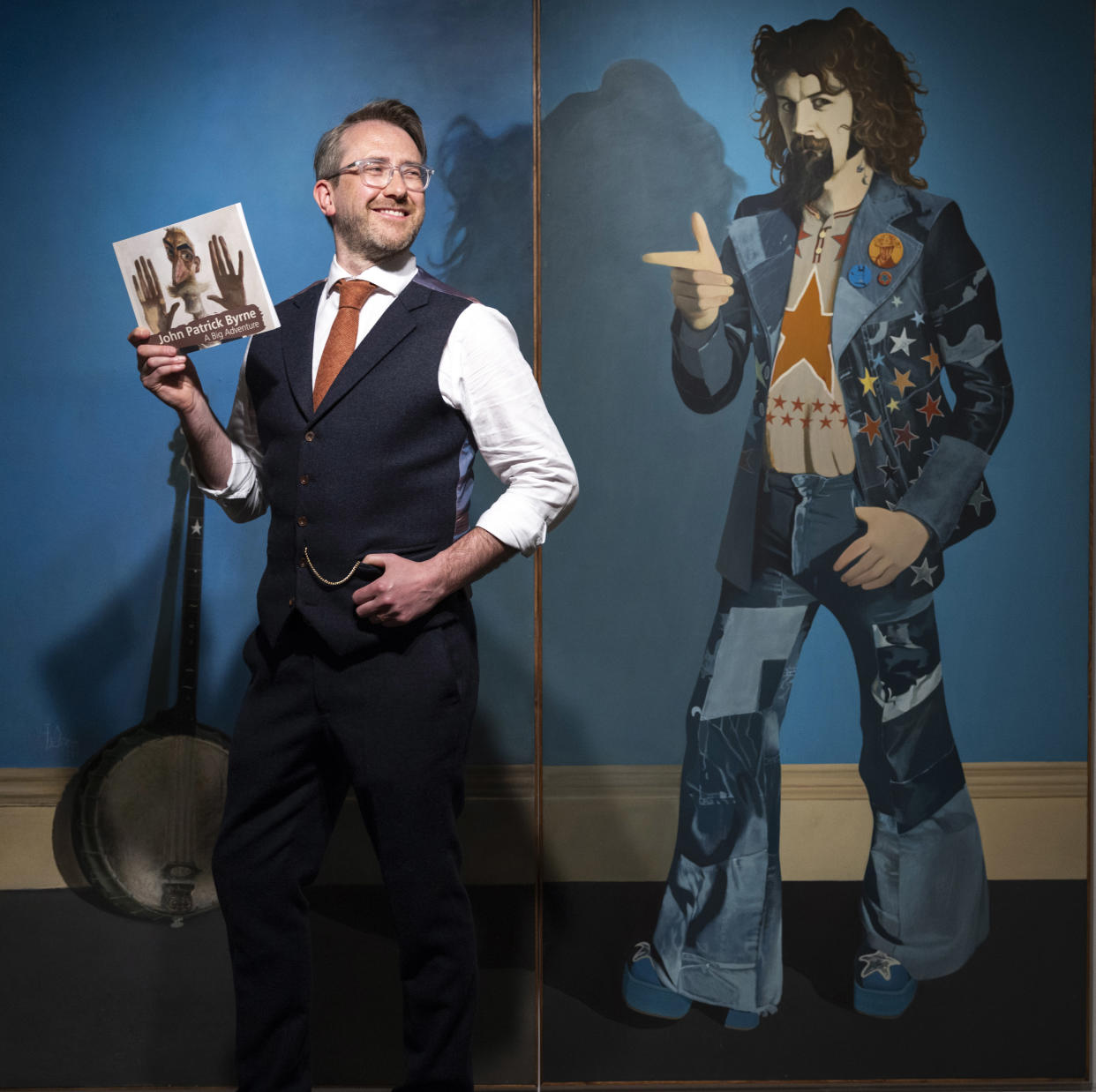 Martin Craig stands next to John Byrne’s portrait of Billy Connolly (Martin Shields/PA)