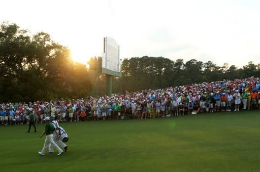 Louis Oosthuizen of South Africa and his caddie Wynand Stander walk down the second sudden death playoff hole fairway on the 10th during the final round of the 2012 Masters Tournament at Augusta National Golf Club in Augusta, Georgia