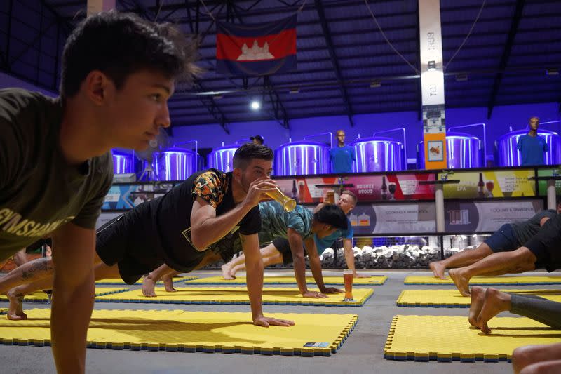 People participate in a beer yoga session, as the country eases COVID-19 restrictions, at a craft brewery in Phnom Penh