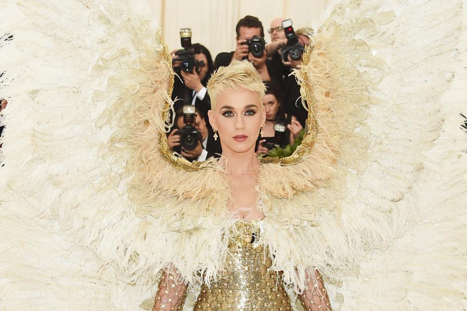 At the 2018 Met Gala, Katy Perry wore feathered angel wings that reached well above her head down to the floor with a gold dress and thigh-high boots.