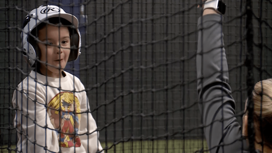 A youngster enjoys the crack of the bat during summer sessions at Bases Loaded in west Las Vegas. (KLAS)