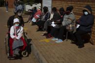 FILE - In this June 3, 2021, file photo, an elderly woman leaves as others wait to receive the Pfizer COVID-19 vaccine, at a clinic at Orange Farm, near Johannesburg. South Africa imposed tighter restrictions on public gatherings and liquor sales as hospital admissions due to COVID-19 increased by 59% over the past two weeks, President Cyril Ramaphosa said on Tuesday, June 15. New cases there have nearly doubled. (AP Photo/Denis Farrell, File)