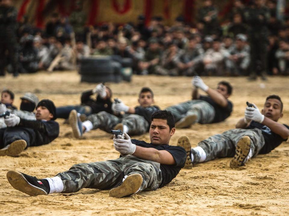 Palestinian high school students show off their skills during a graduation ceremony from a military school course organised by the Hamas security forces and the Hamas Ministries of Interior and Education (Getty)