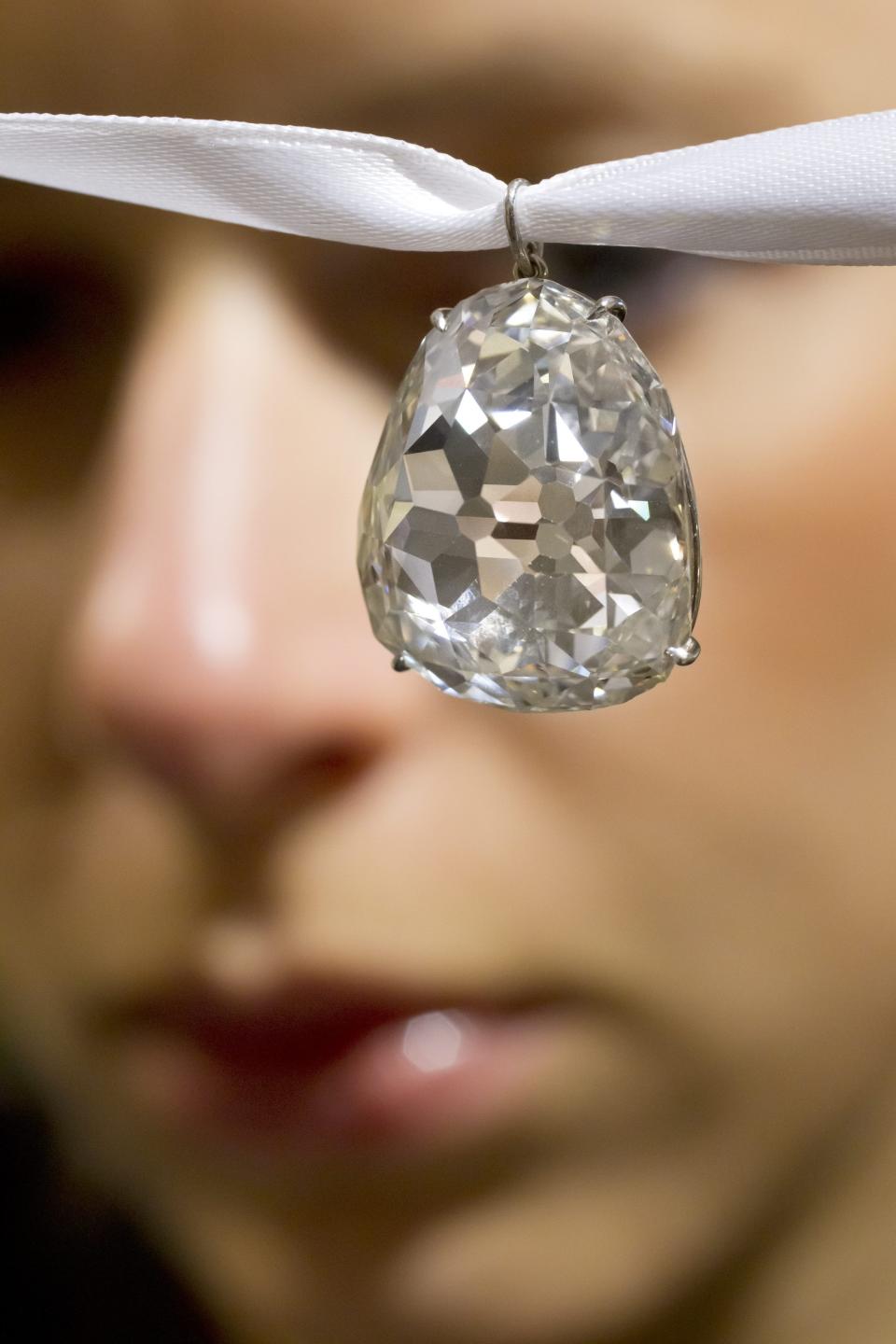 FILE - In this May 2, 2012 file photo an employee shows the Beau Sancy diamond, 34.98 carat, at Sotheby's auction house in Zurich, Switzerland. Marie de Medici wore it at her coronation as Queen Consort of Henry IV in 1610, and now the Beau Sancy diamond is a lavish accessory owned by an anonymous bidder who paid US $9.7 million (7.6 million euro) for it at Sotheby’s auction in Geneva Tuesday May 15, 2012. The spring auction season for jewelry and watches is upon Geneva, where elegant lakefront hotels fill with well-heeled buyers and bidders in a scene far removed from the debate over European austerity. (AP Photo/Keystone, Alessandro Della Bella, File)