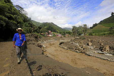 A resident walks in front of houses that were destroyed after a landslide sent mud and water crashing onto homes close to the municipality of Salgar in Antioquia department, Colombia May 19, 2015 .REUTERS/Jose Miguel Gomez