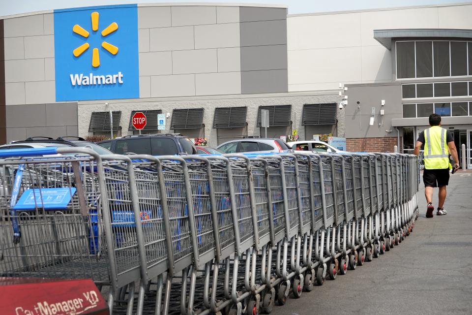 A worker collects shopping carts from the parking lot of a Walmart store in Chicago.