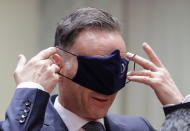 German Foreign Minister Heiko Maas puts on a face mask, to prevent the spread of coronavirus, as he attends an EU foreign ministers at the European Council building in Brussels, Monday, July 13, 2020. European Union foreign ministers meet for the first time face-to-face since the pandemic lockdown and will assess their discuss their relations with China and Turkey. (Stephanie Lecocq, Pool Photo via Ap)