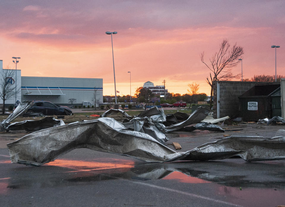 Debris covers a parking lot as the sun sets after a tornado in Jonesboro, Ark., Saturday, March 28, 2020. (Quentin Winstine/The Jonesboro Sun via AP)