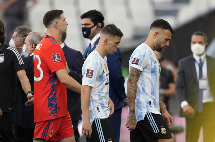 Argentina's Nicolas Otamendi, right, Argentina's Giovani Lo Celso, center, and Argentina goalkeeper Emiliano Martinez walk off the field as the game against Brazil is interrupted by health authorities during a qualifying soccer match for the FIFA World Cup Qatar 2022 at Neo Quimica Arena stadium in Sao Paulo, Brazil, Sunday, Sept. 5, 2021. Argentina walked off the field Sunday after only seven minutes of its World Cup qualifier against host Brazil after health officials came onto the pitch following coronavirus concerns about three Argentina players. (AP Photo/Andre Penner)