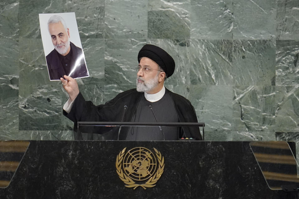 President of Iran Ebrahim Raisi holds up a photo of slain Iranian Gen. Qassem Soleimani, as he addresses the 77th session of the United Nations General Assembly, Wednesday, Sept. 21, 2022 at U.N. headquarters. (AP Photo/Mary Altaffer)