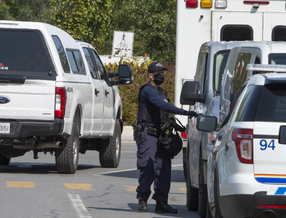 A Royal Canadian Mounted Police officer walks outside of an apartment complex Monday, Sept. 21, 2020, in St-Hubert, Quebec, during a raid in connection with an envelope containing the poison ricin, which was addressed to the White House. (Ryan Remiorz/The Canadian Press via AP)